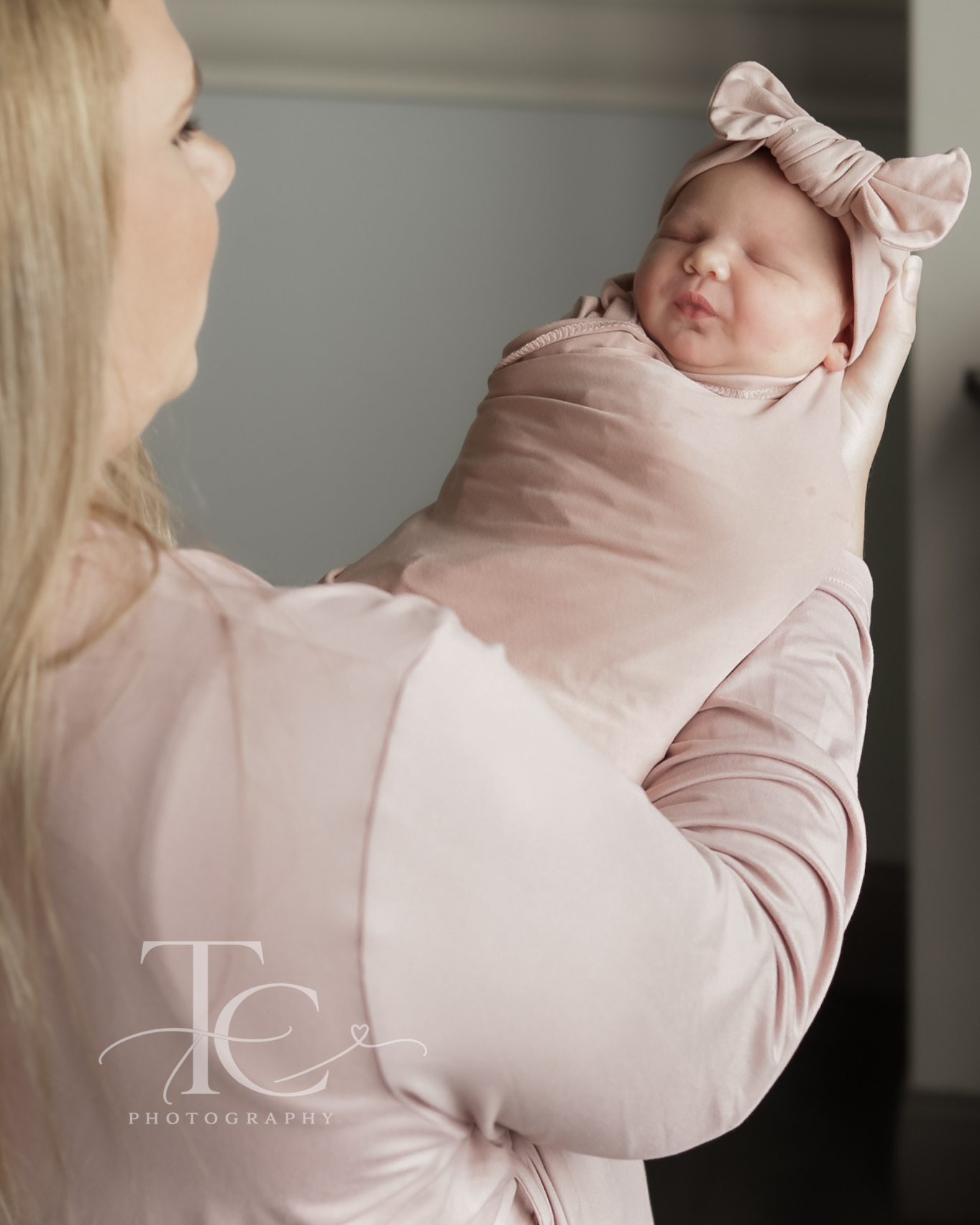 Mother holding her newborn in a pink wrap