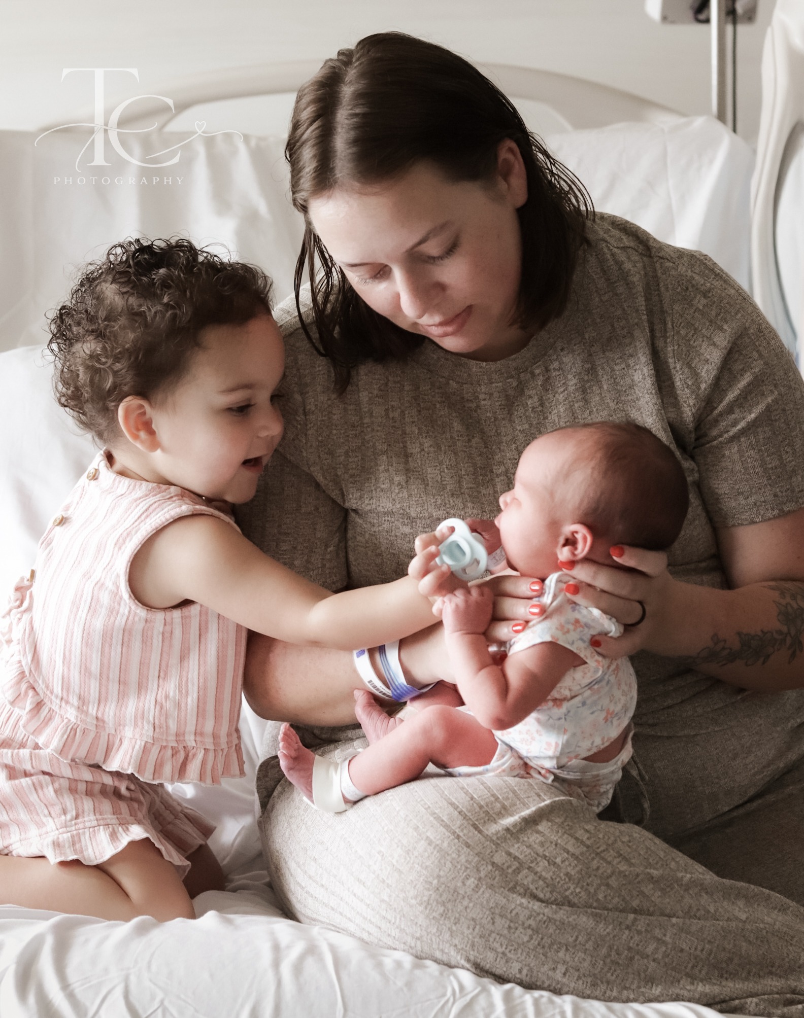 Older sibling meeting newborn in mother’s arms