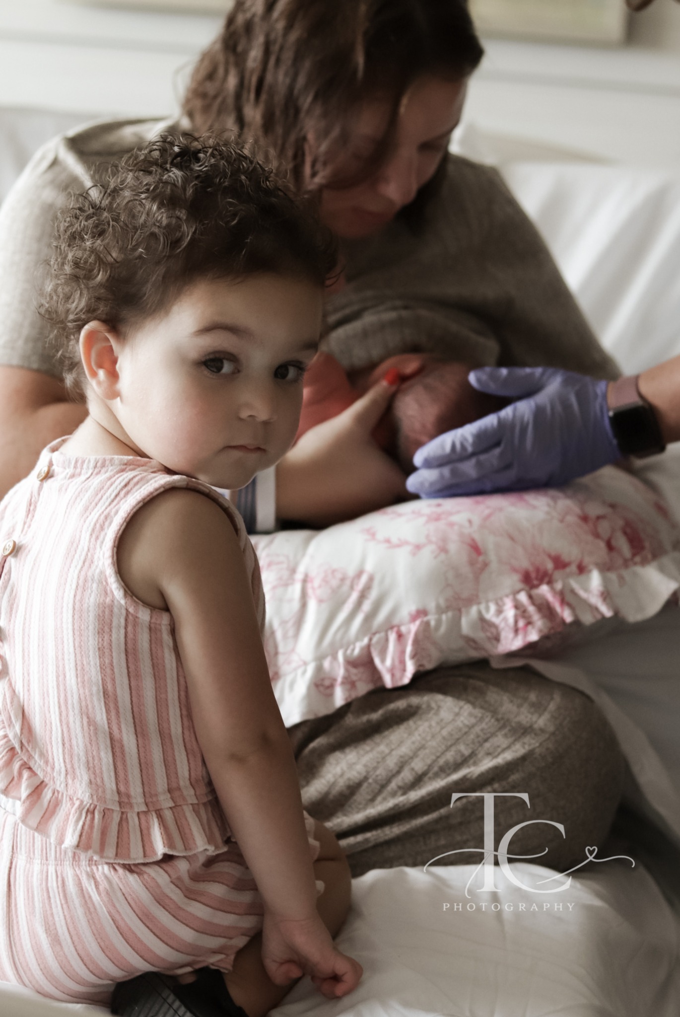 Older sibling beside mother holding newborn