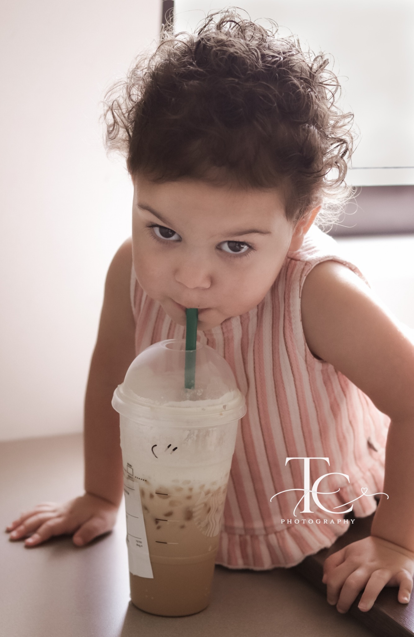 Little girl enjoying a drink beside the hospital window