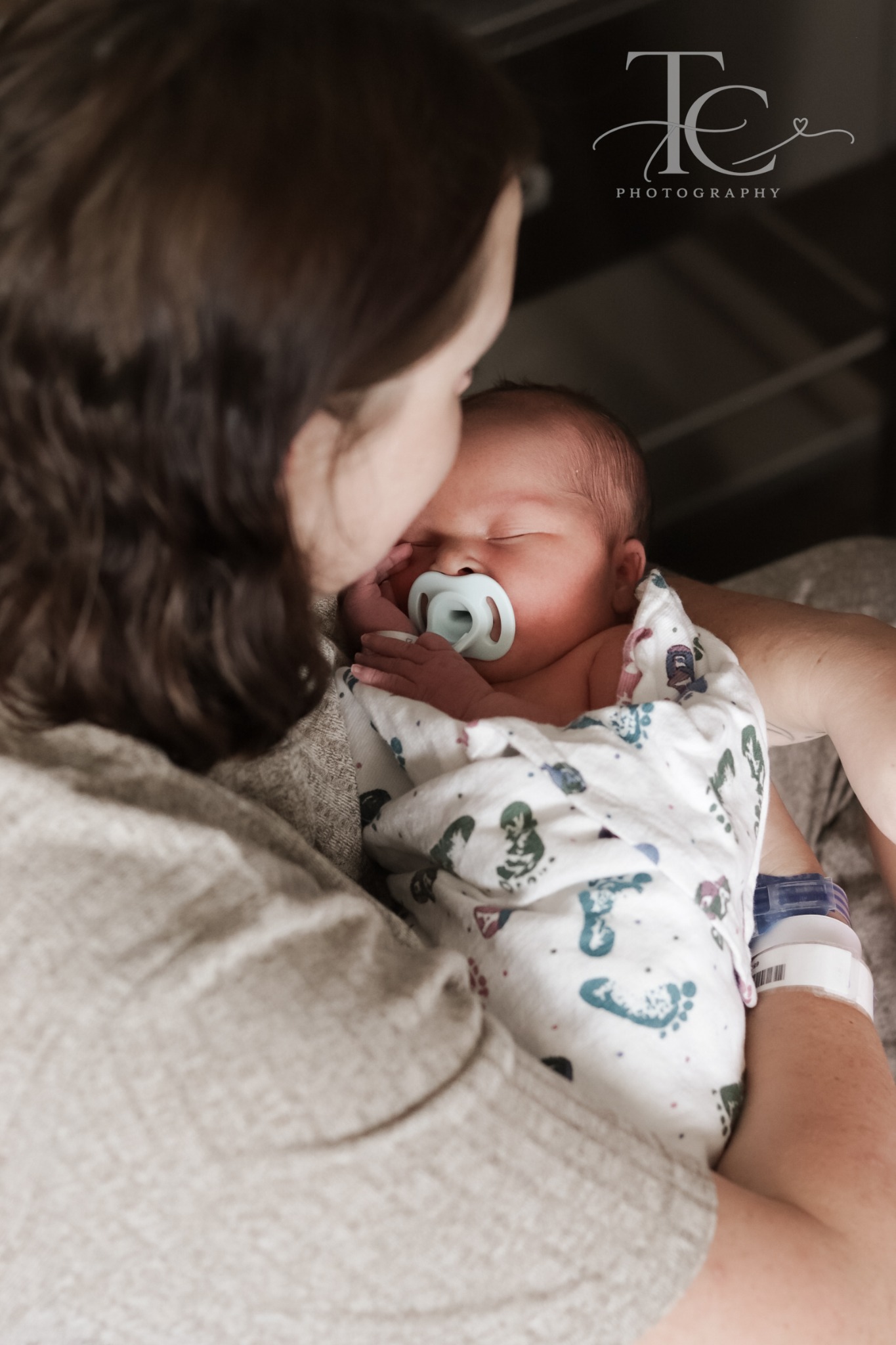 Mother holding her swaddled newborn