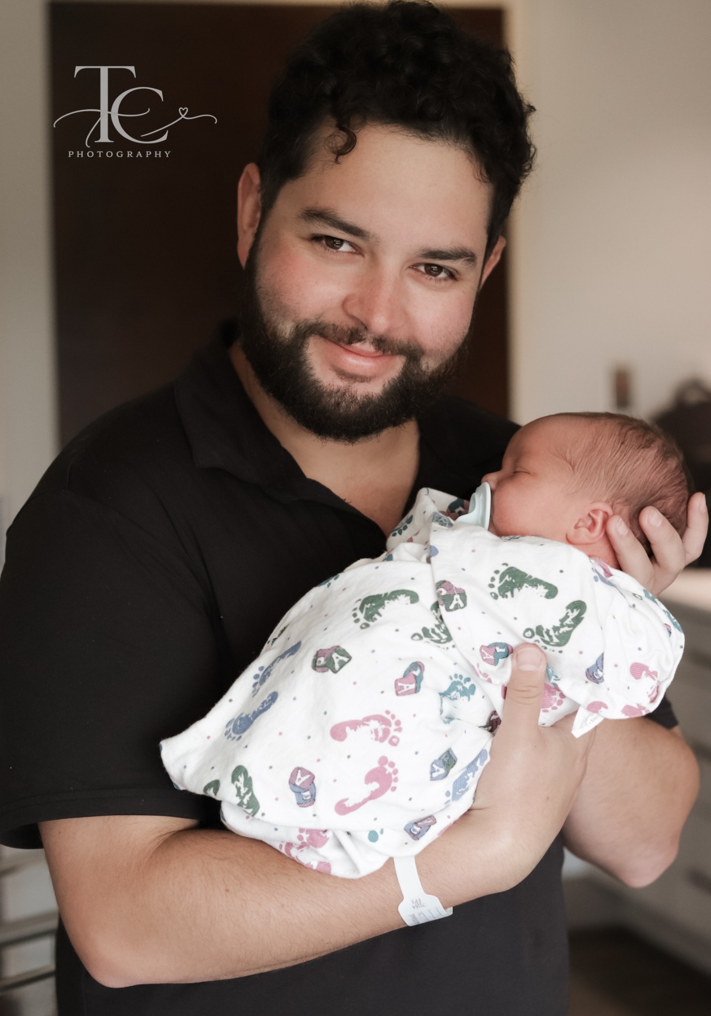 Father holding his swaddled newborn