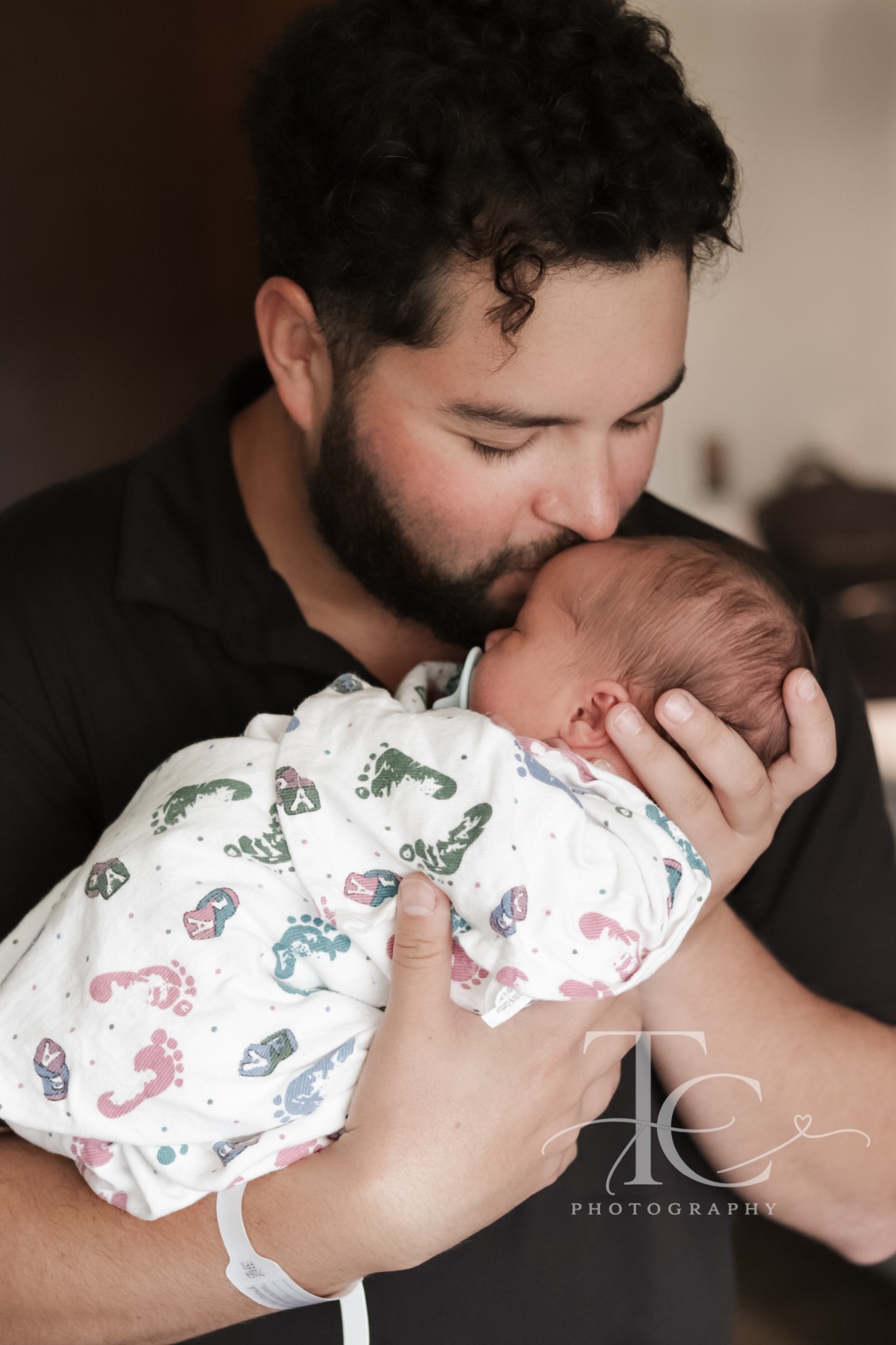Father kissing his newborn’s head