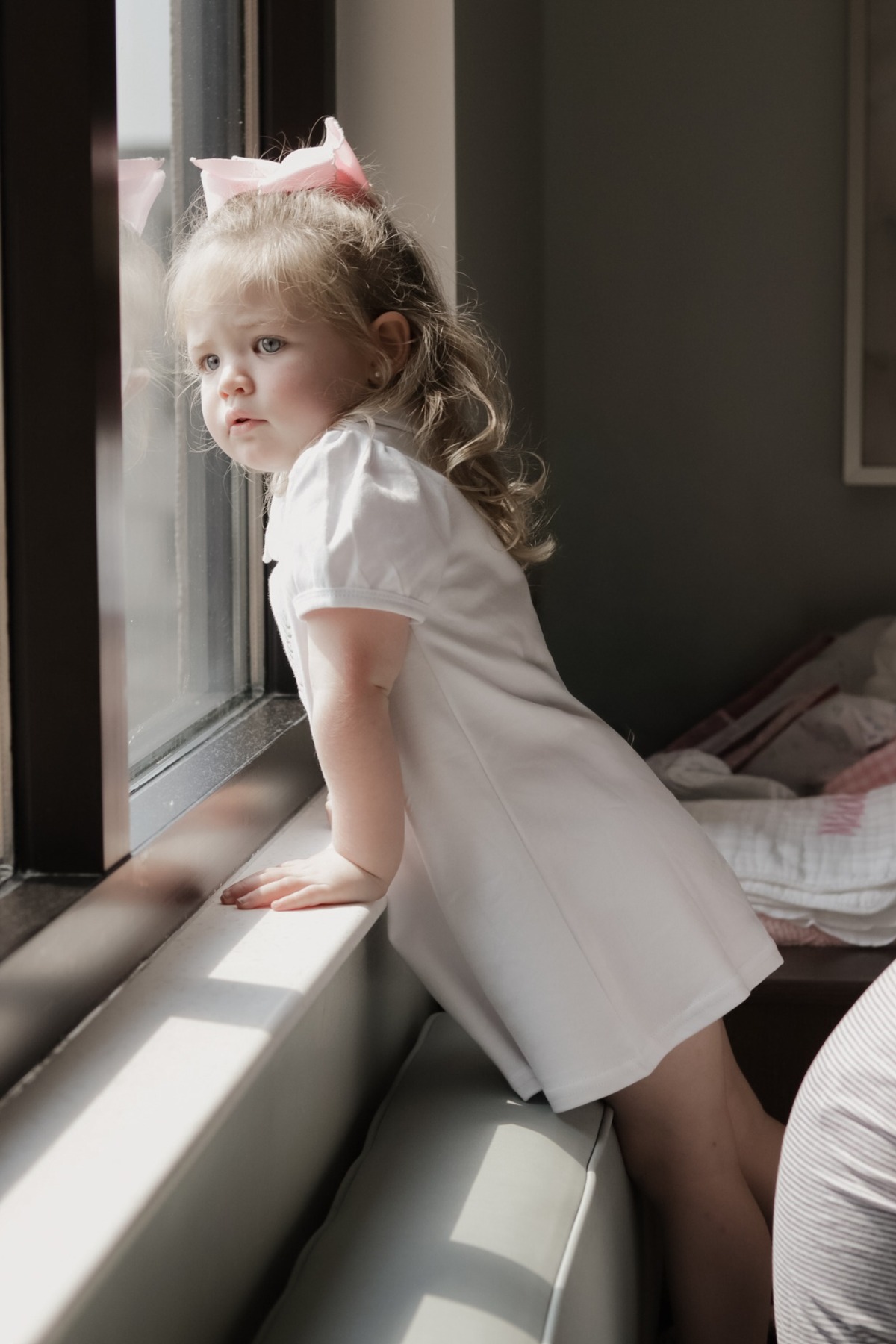 Young girl looking out of a hospital room window