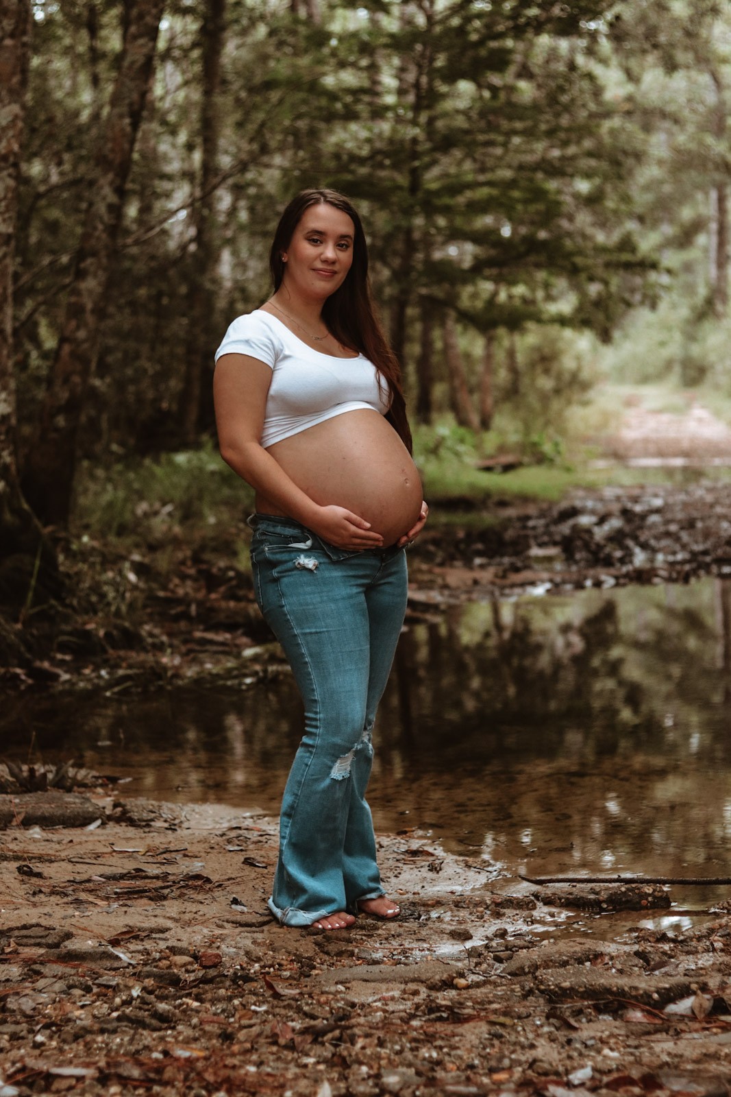 Expectant mother standing on a woodland path