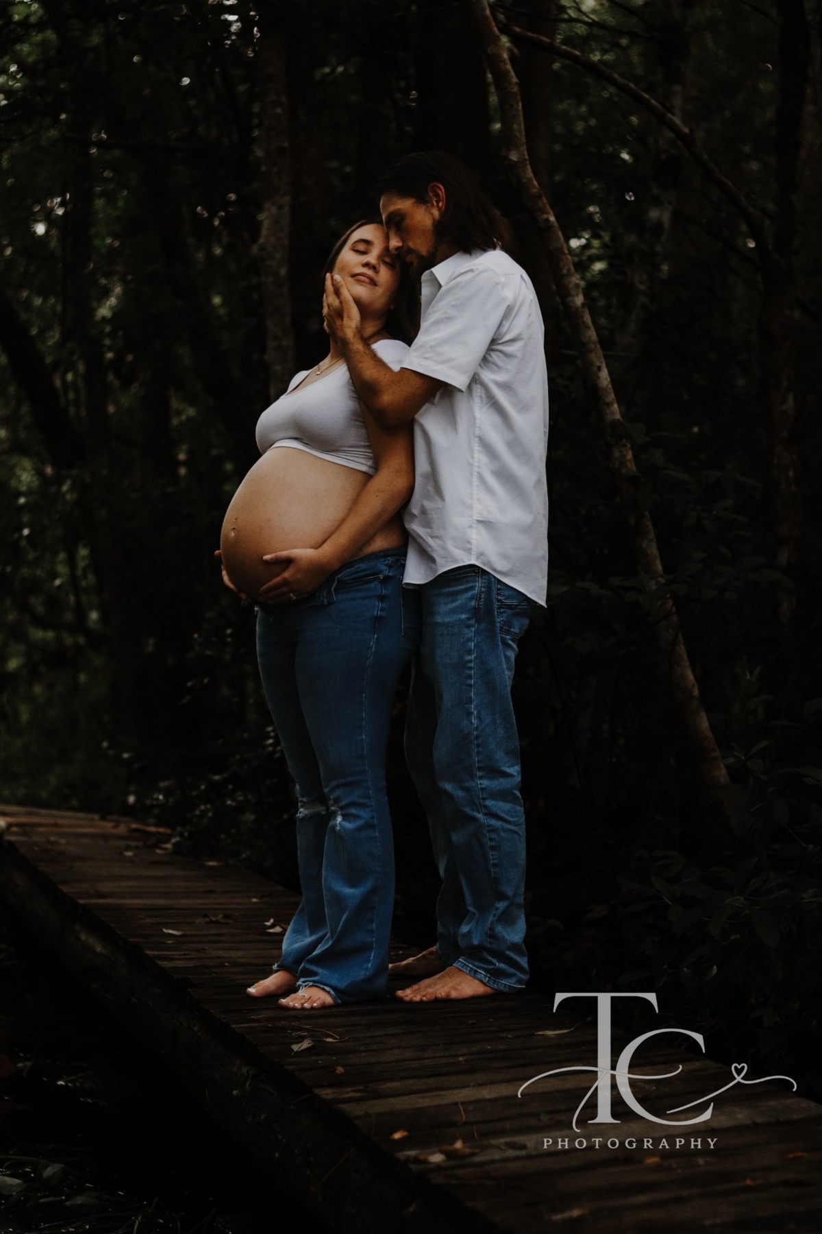 Couple embracing on a wooded walkway