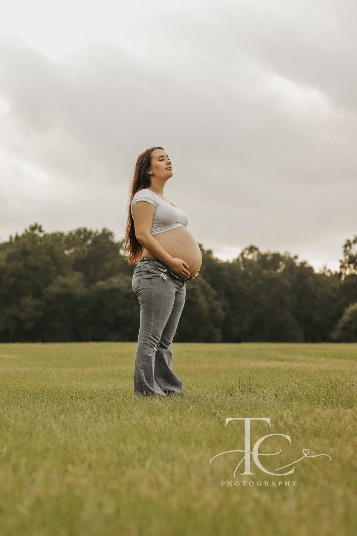 Expectant mother standing in an open field