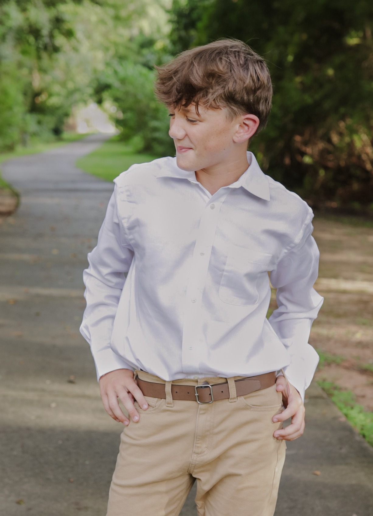 Teen boy looking to the side on a wooded path