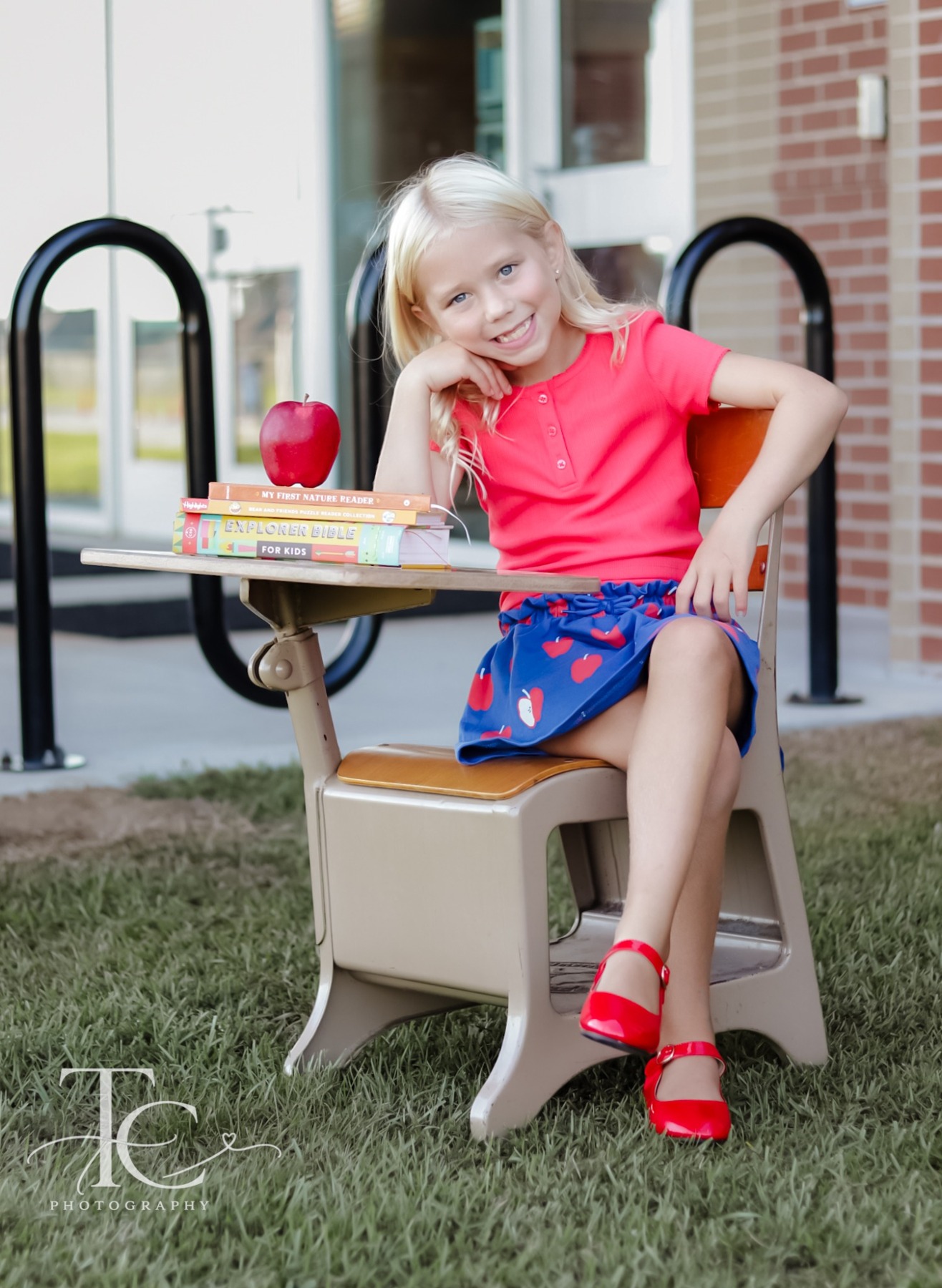 Girl smiling at a school desk outdoors